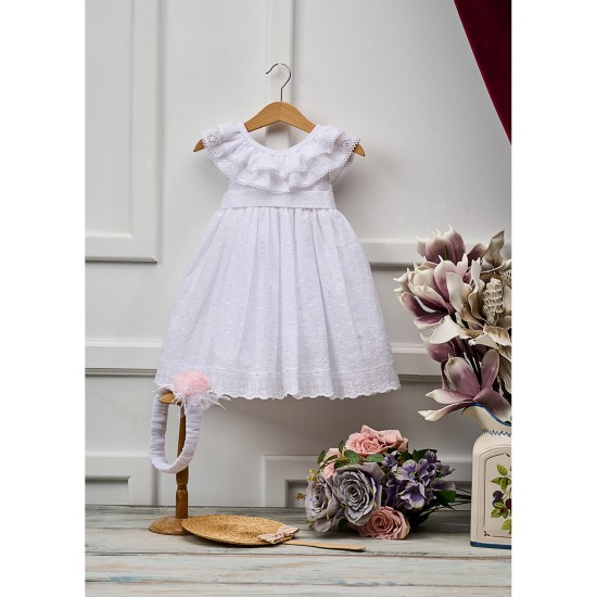  Φόρεμα βάπτισης από βαμβακερό μπροντερί σε λευκή απόχρωση με σχέδιο μαργαρίτες, με διπλό βολάν στον λαιμό. Το φόρεμα συνοδεύεται με κορδέλα και χειροποίητο λουλούδι.